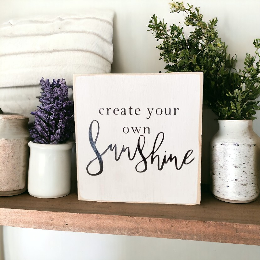 4"x4" white wooden block sign with black text reading, Create Your Own Sunshine