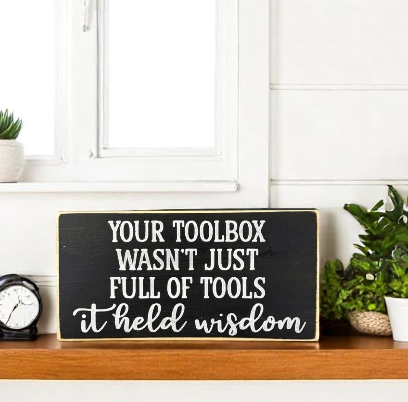 Handpainted black wood sign with white text that reads “Your toolbox wasn’t just full of tools – it held wisdom,” a heartfelt gift idea for Dad.