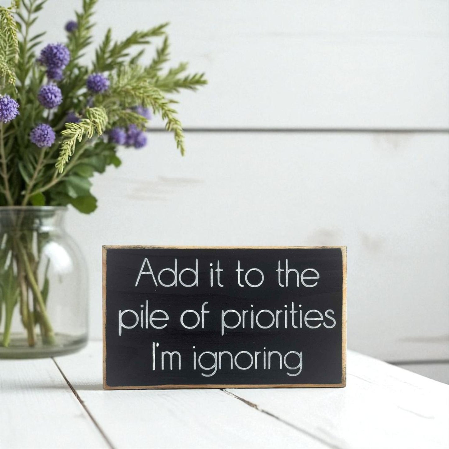 Handmade funny office desk sign reading “Add It to the Pile of Priorities I’m Ignoring” – sarcastic office decor, 3.5" x 6" wood block, witty workplace gift.