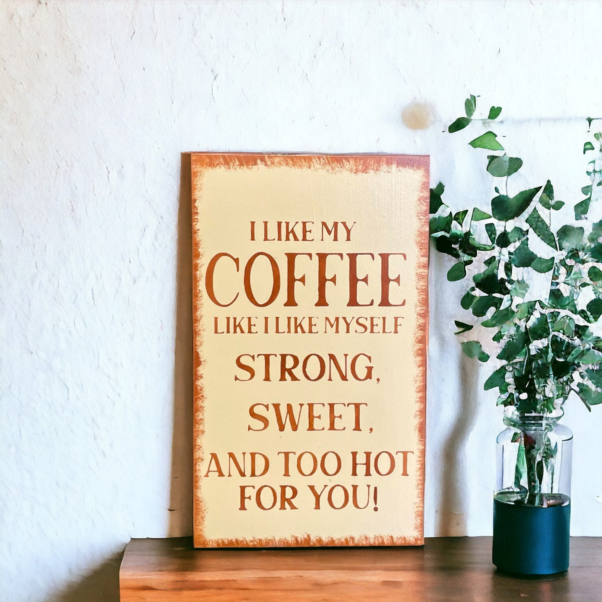 Funny coffee sign with quote 'I Like My Coffee like I like myself, strong, sweet, and too hot for you' on a creamy light brown background with dark brown text and brown border.