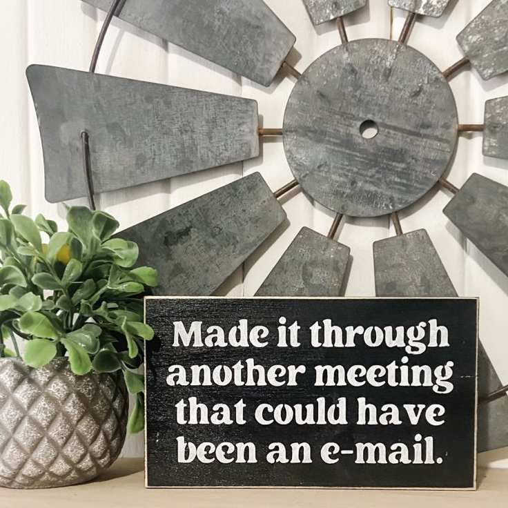 A witty mini wood sign, measuring 3.5" x 6", featuring the phrase, 'Made it through another meeting that could have been an email.' The sign is in bold white text on a black background. This funny decor piece is an ideal funny coworker gift or a hilarious gift for your boss, adding a touch of humor to your workspace.