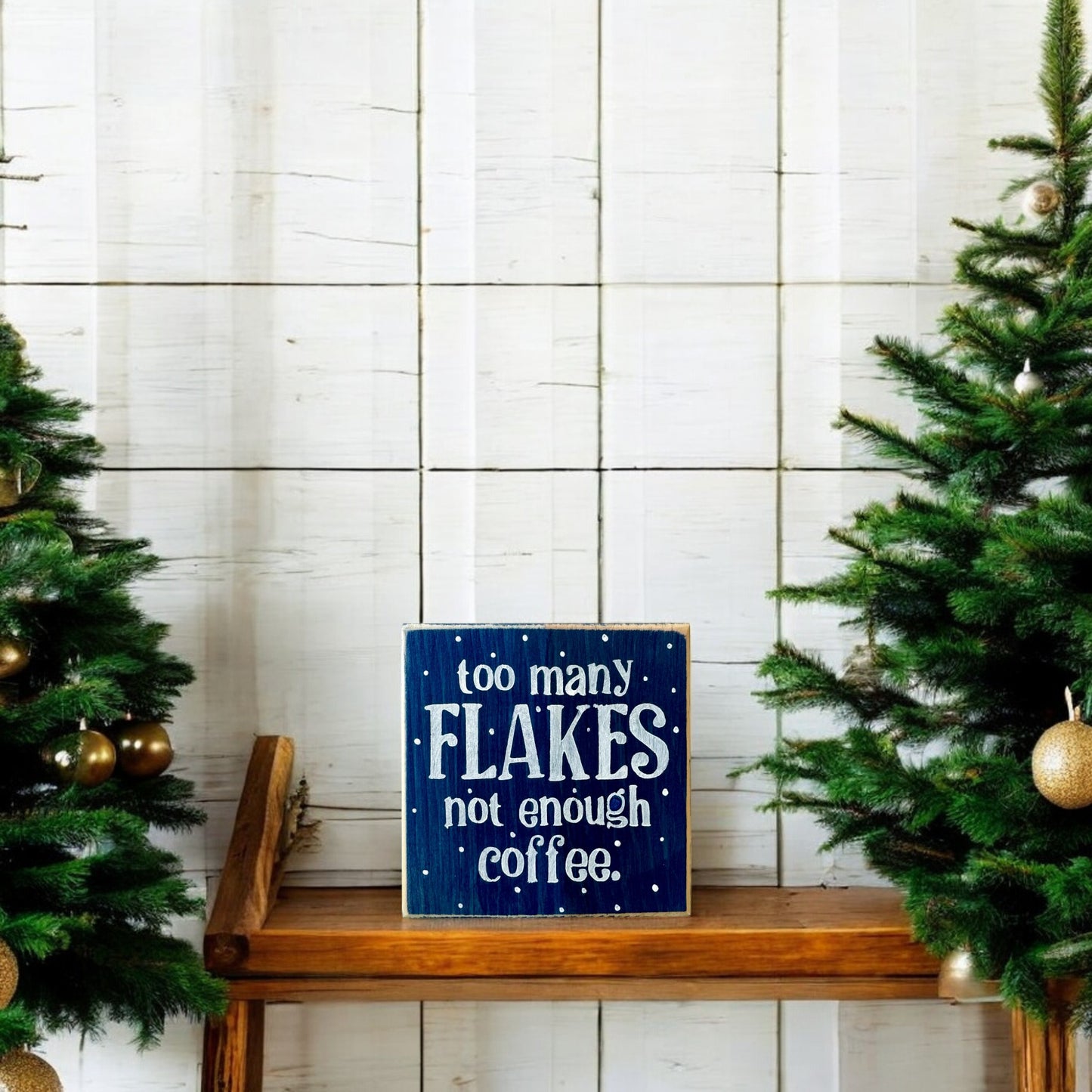 Handpainted wood block sign reading “Too Many Flakes, Not Enough Coffee” in white text on a navy blue background, surrounded by snowflakes, ideal for winter decor and coworker gifts.