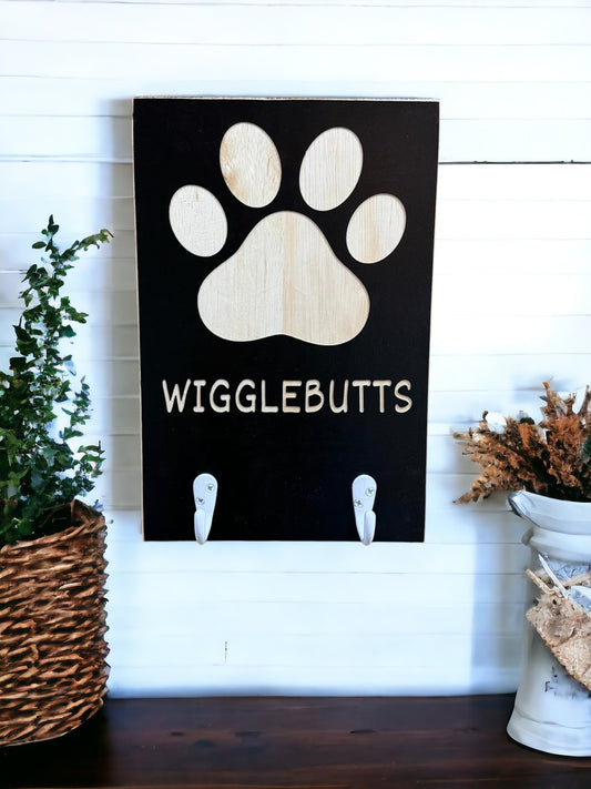 8" x 12" wooden wall hanging that says "Wigglebutts" with white metal hooks – a funny dog quote dog leash holder, perfect for pet lovers.