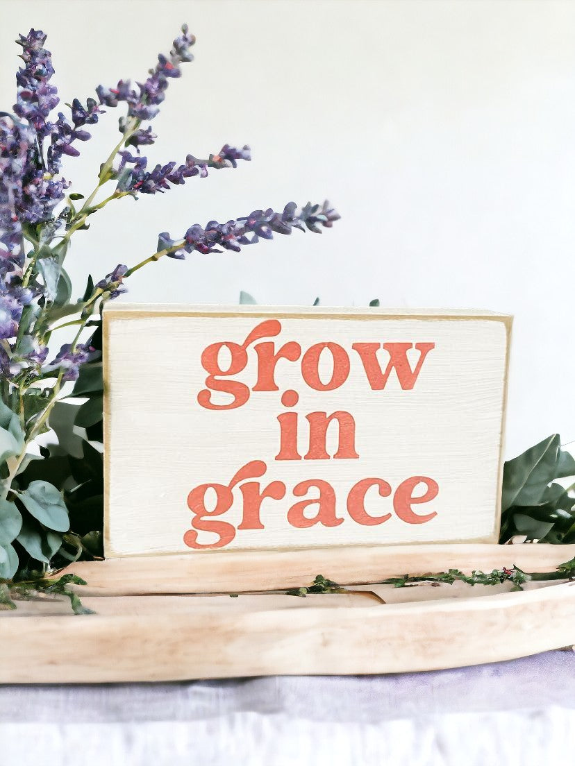Grow in Grace" Scripture Art Wood Block Sign: Hand-painted pink text on white background, 3.5" x 6". Perfect for spiritual decor.