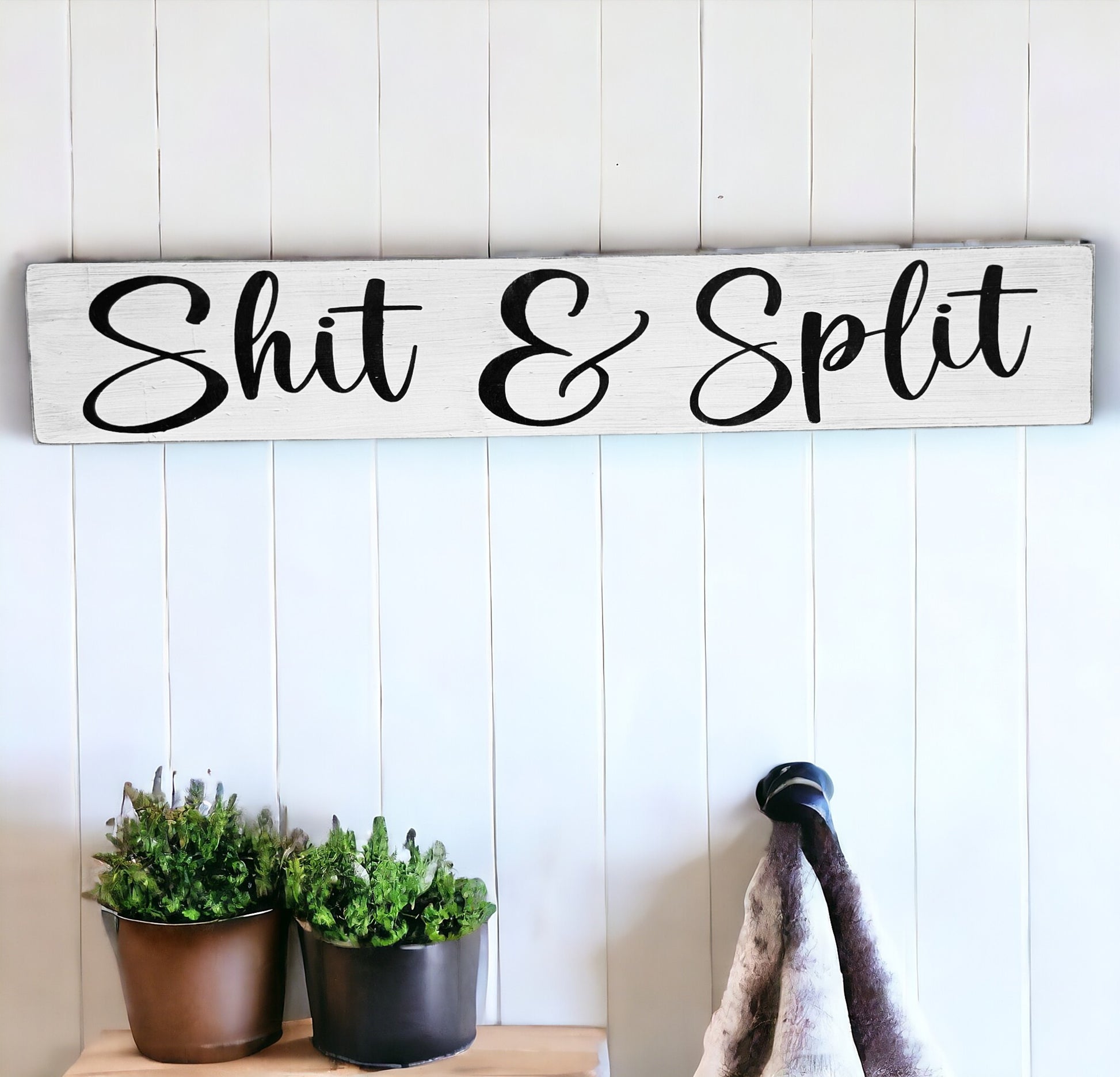 Handcrafted wooden bathroom sign with black text on white background: 'Shit & Split.' Measures 4" x 24". Adds humor to bathroom decor.