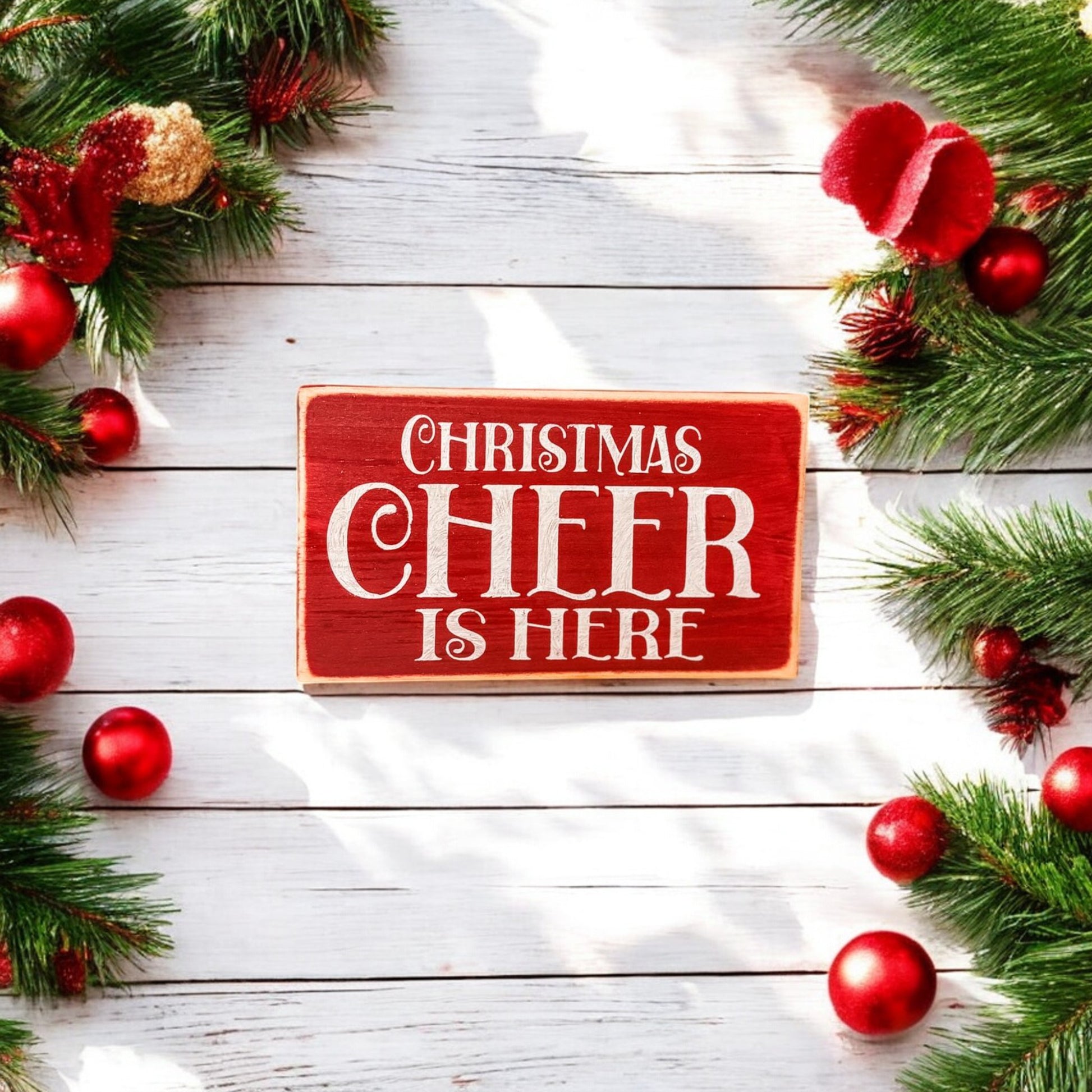 3.5" x 6" wood block sign reading "Christmas Cheer is Here," handpainted in festive holiday red with white text.