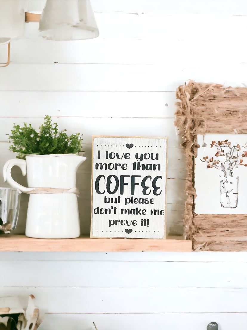 A 3.5" x 5" rustic block sign with a white background and whimsical black text that reads, 'I love you more than coffee but please don't make me prove it.' This coffee sign is a charming addition to any coffee lover's space, adding a cute and funny touch to their coffee bar decor.