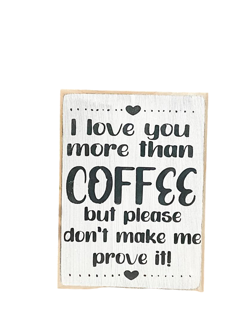A 3.5" x 5" rustic block sign with a white background and whimsical black text that reads, 'I love you more than coffee but please don't make me prove it.' This coffee sign is a charming addition to any coffee lover's space, adding a cute and funny touch to their coffee bar decor.