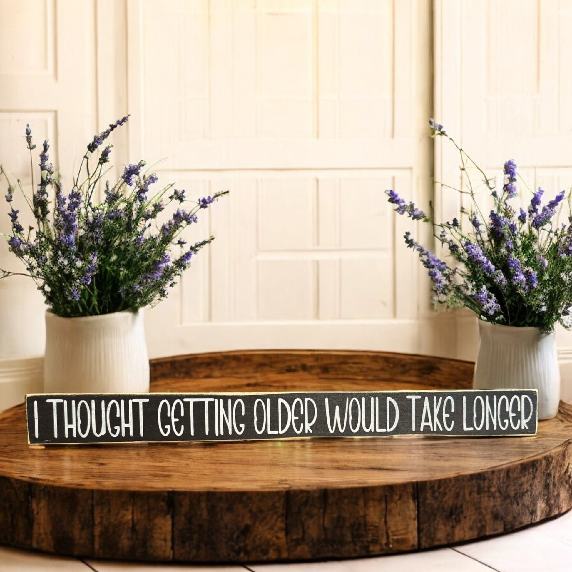 Black and white wooden sign with text reading 'I Thought Getting Older Would Take Longer' - perfect for funny age quotes and humor decor.