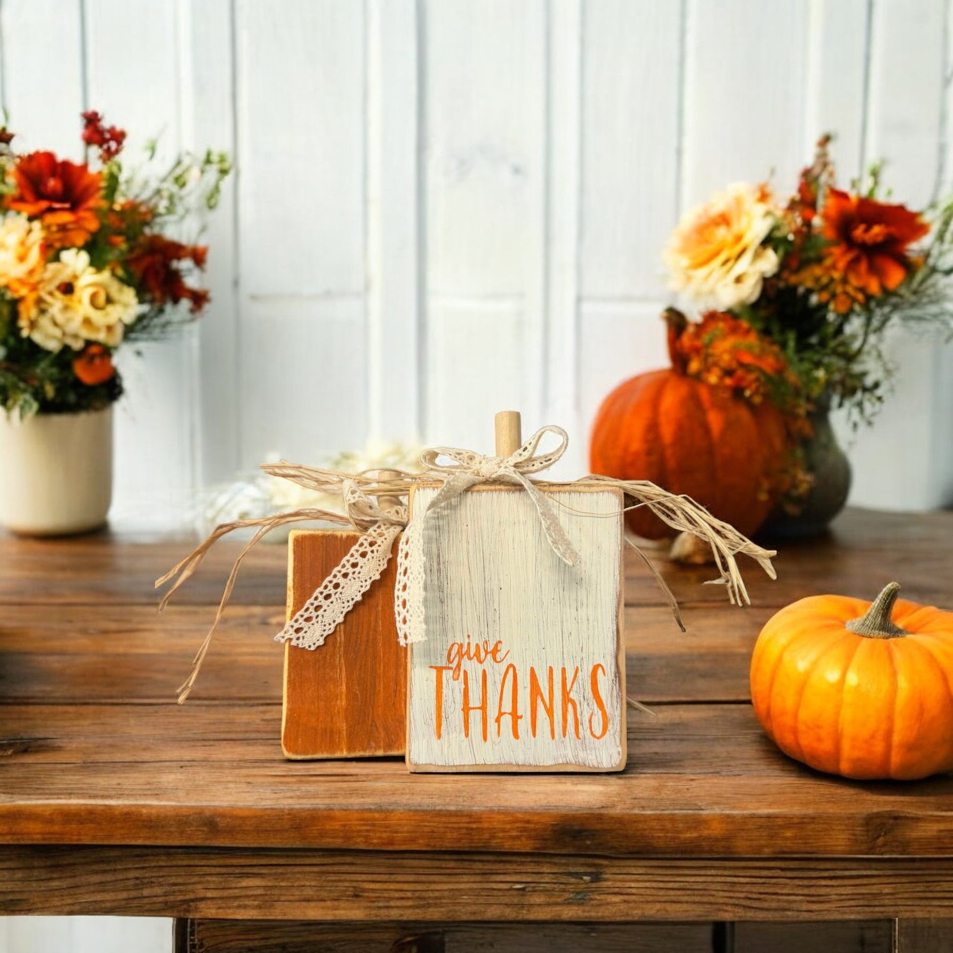 Handcrafted wood pumpkins for Thanksgiving decorations—one orange and one distressed white with "Give Thanks," perfect shelf sitters for fall decor.