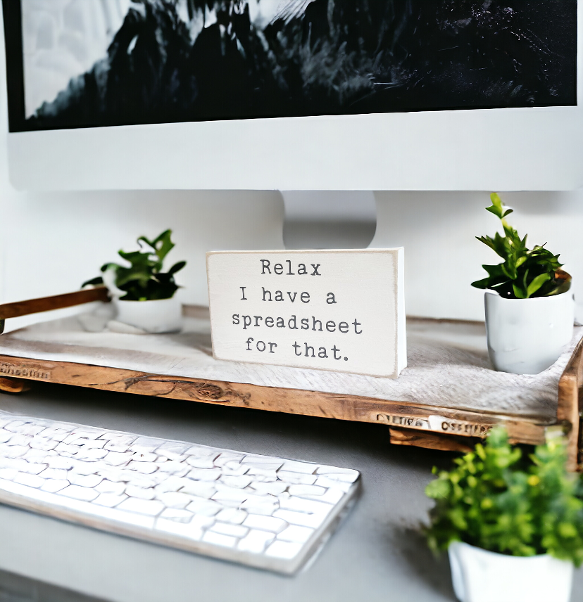Image: A 3.5" x 6" wood desk sign in crisp white with playful typewriter gray text that reads, 'Relax, I have a spreadsheet for that.' Perfect for gifting to the spreadsheet enthusiast in your life, this compact sign adds a touch of organized humor to any desk, office shelf, or bookcase.