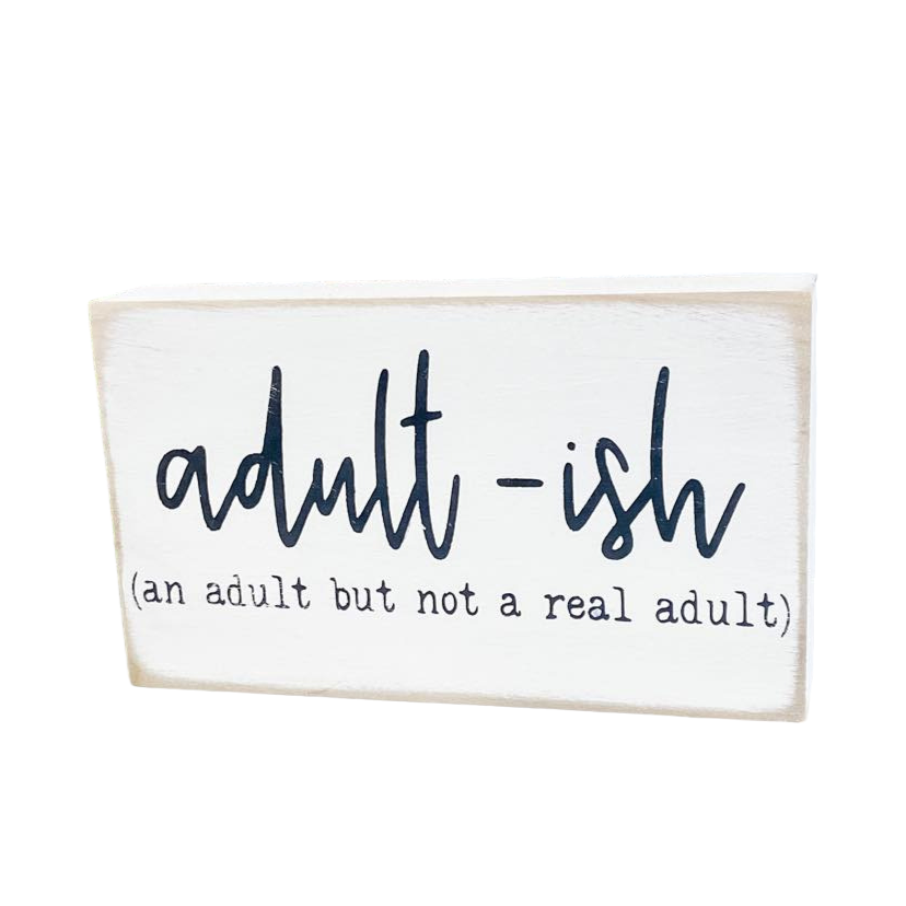 : A 3.5" x 6" wood block sign with a white background and amusing black text that reads, 'Adultish, an adult but not a real adult.' This freestanding sign is the perfect funny office sign, adding a dose of adulting humor to your workspace.