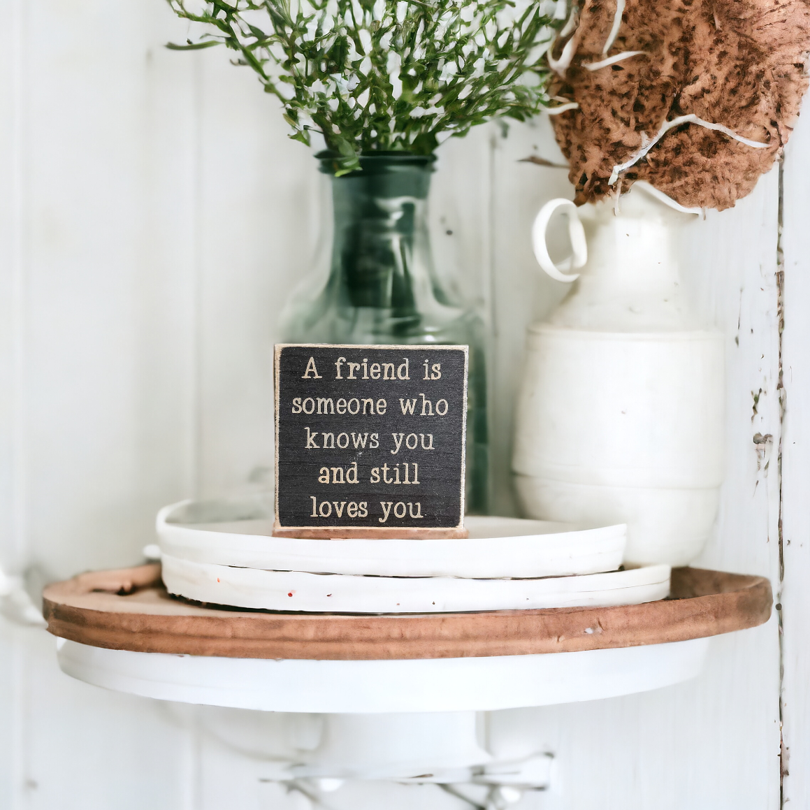 Image of a 4.5-inch wooden block sign with khaki text that reads, 'A friend is someone who knows you and still loves you.' Ideal decor and heartfelt gift for girls, emphasizing the essence of true friendship.