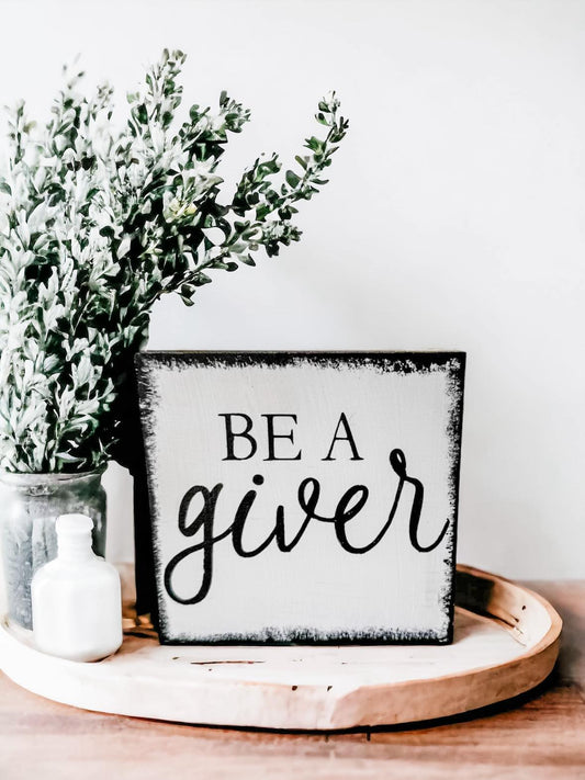 Be a Giver" Wood Block Sign: Hand-painted black text on white background with rustic black brush strokes border, 4.5"x4.5". Perfect for inspiring kindness.