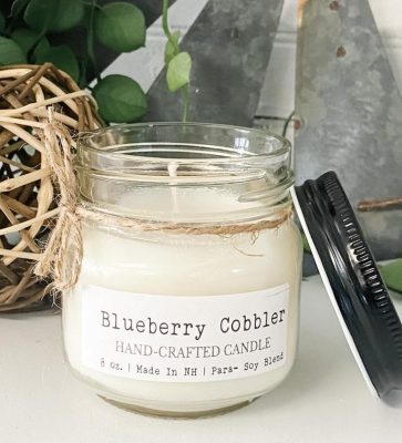 A phthalate-free Blueberry Cobbler Mason Jar Candle, meticulously hand-poured with high-quality 8 oz para-soy wax and fragrant oils. This inviting candle fills your space with the comforting scent of freshly baked blueberry cobbler, creating a warm and cozy atmosphere in your home.