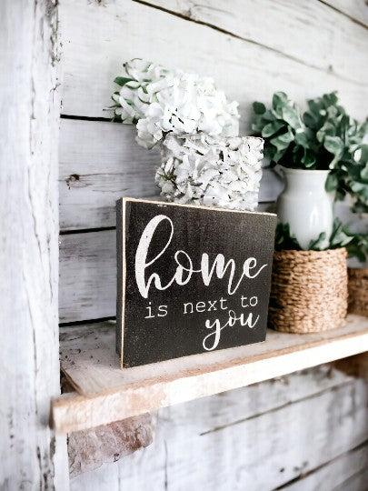 Home is Next to You" wooden block sign with black background and white text, perfect for shelf or tabletop display.