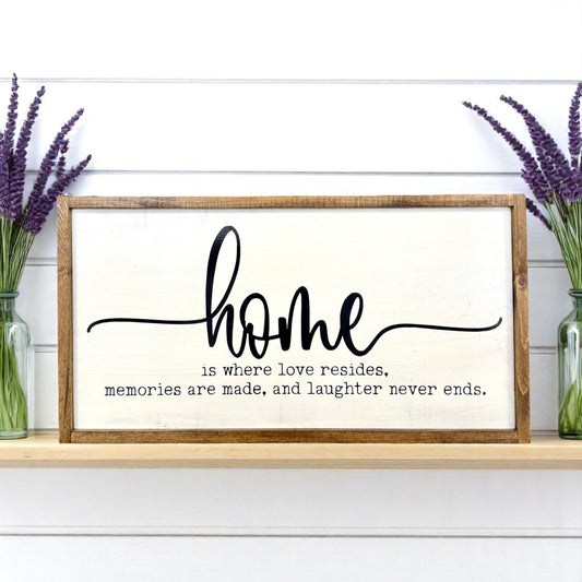 Framed wooden wall art that reads “Home is where love resides, memories are made, and laughter never ends” – perfect gift for family or housewarming