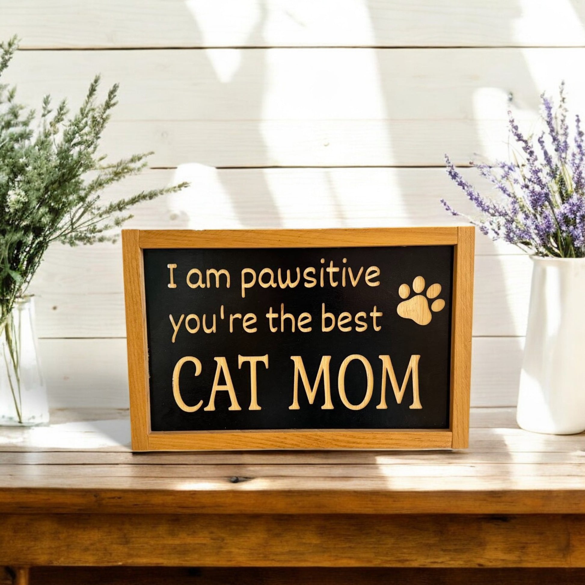 Framed carved wooden sign reading 'I'm Pawsitive You're the Best Cat Mom,' handpainted black with natural wood lettering and a stained frame. Perfect cat mom gift and cat decorations, ready to hang with attached hardware.