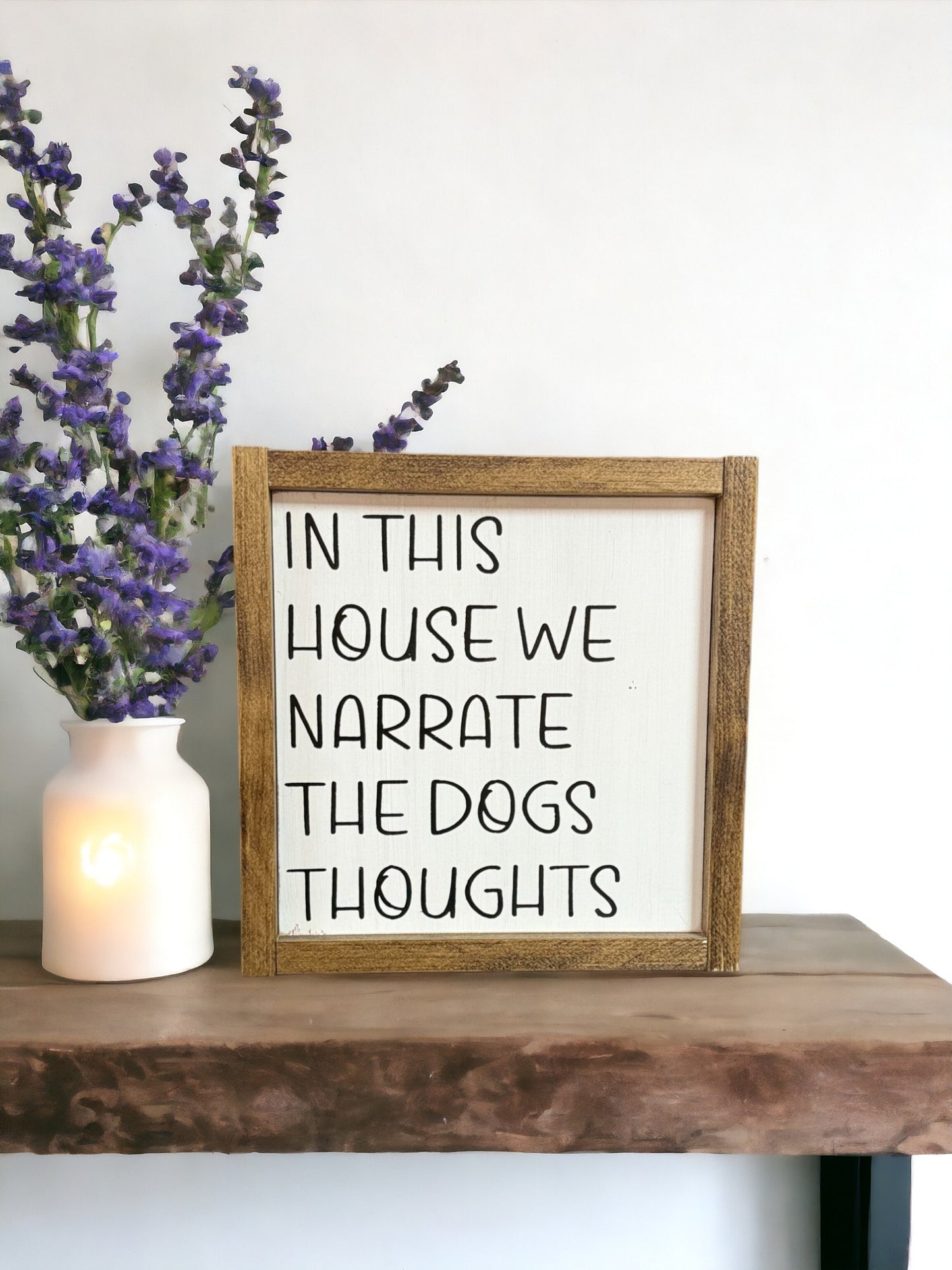 Handcrafted wooden sign with humorous dog quote: 'In this house we narrate the dogs' thoughts.' White background with black text and dark walnut stained frame.