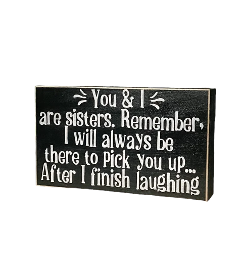 A 3.5" x 6" rustic wood block sign with a black background and playful white text that reads, 'You & I Are Sisters, Remember, I Will Always Be There To Pick You Up After I Finish Laughing.' This funny sister gift is the perfect way to share sibling humor in a laid-back and light-hearted manner.