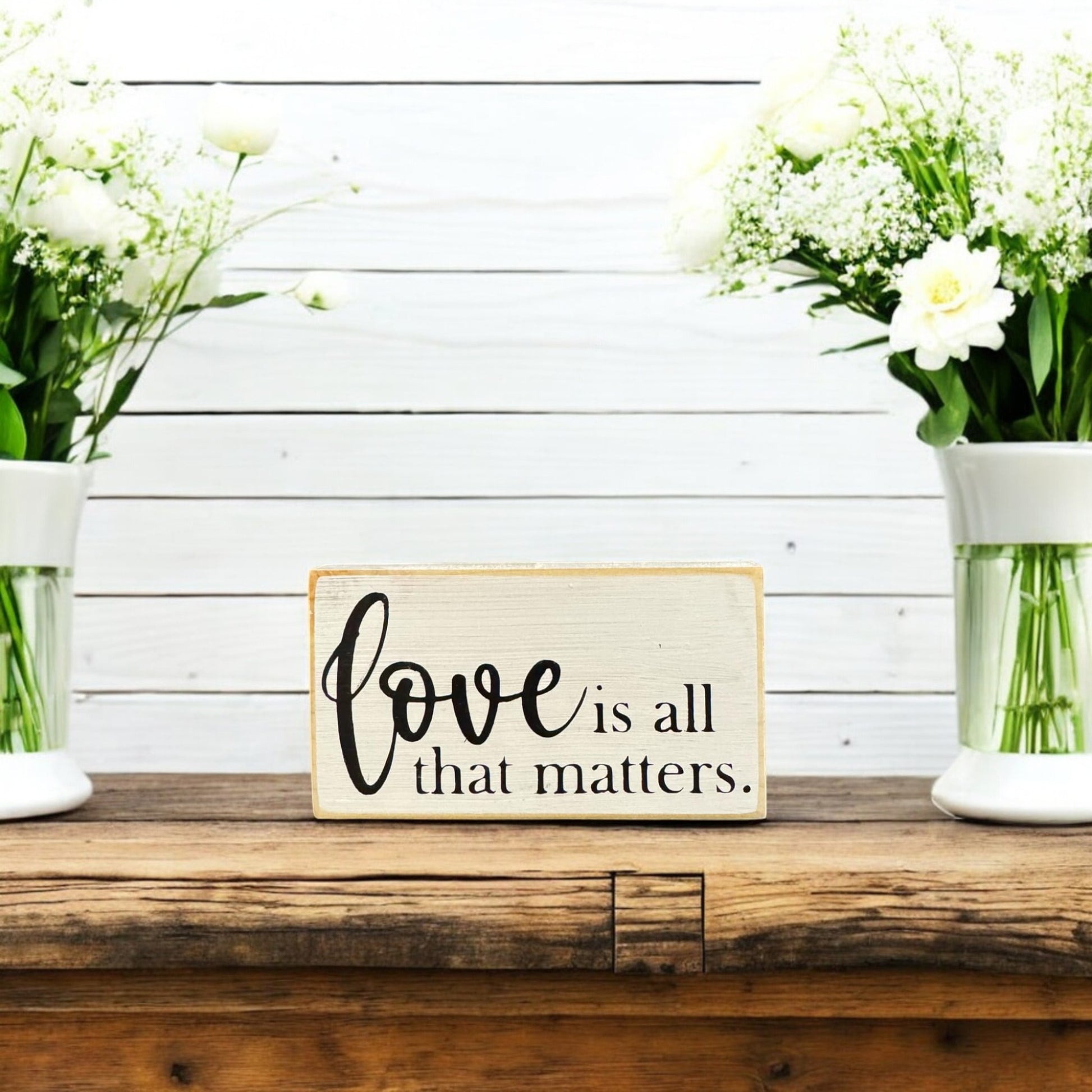 Rustic small wood sign reading 'Love is all that matters,' hand-painted white with black text for Valentine's Day decor or gifting