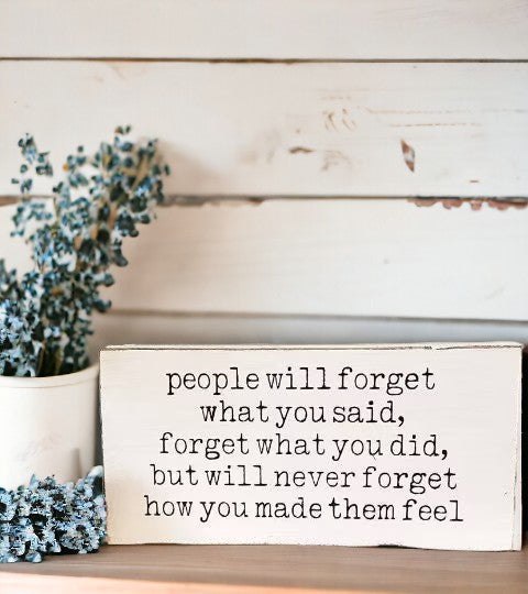 Image of a 4" x 8" handcrafted wood sign featuring elegant black text against a pristine white background. The quote reads: 'People will forget what you said, forget what you did, but will never forget how you made them feel.' Perfect for adding inspiration to any space.