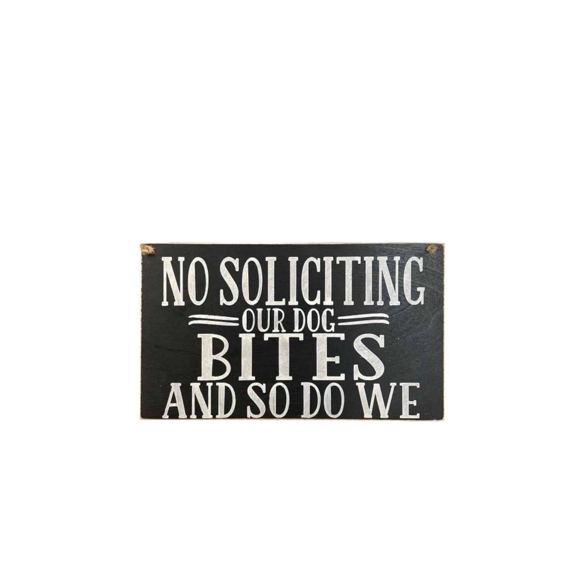 Wooden 'No Soliciting – Our Dog Bites and So Do We' sign, handpainted black with white text. Features a twine hanger for easy hanging. Funny beware of the dog sign for pet lovers.