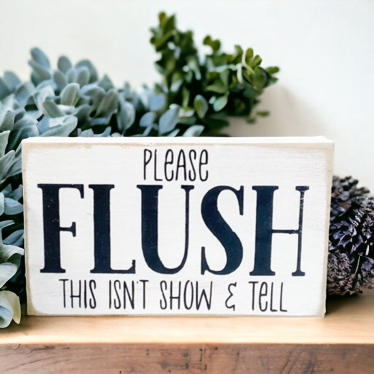 Wooden block sign with humorous bathroom message: 'Please Flush - This Isn't Show and Tell