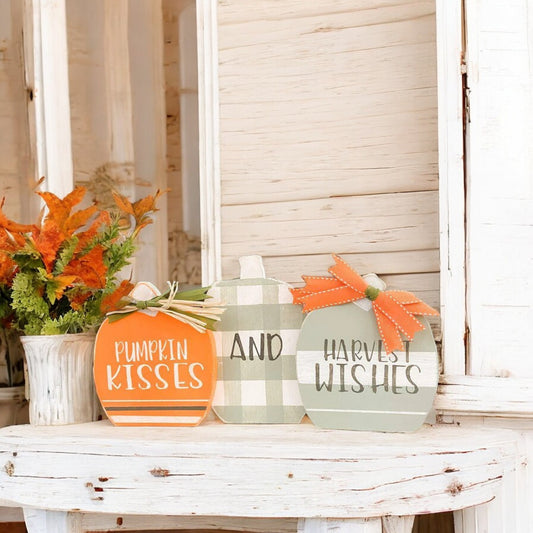 Three joined wooden pumpkins with "Pumpkin Kisses And Harvest Wishes" hand-painted on them, designed as a shelf sitter for Autumn decor.