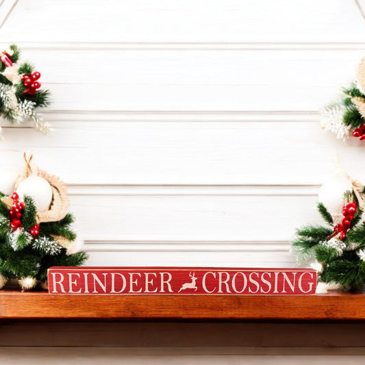 Handpainted rustic wood sign reading “Reindeer Crossing” in white text on a vibrant red background, ideal for farmhouse Christmas mantel decor and festive reindeer decor.

