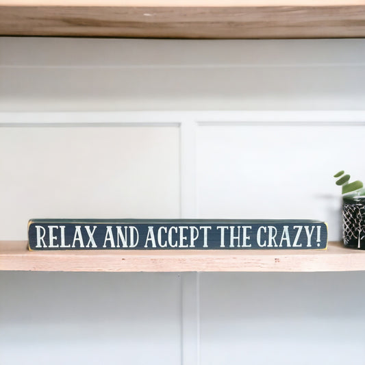 Handpainted bluish-gray wood sign with white text reading 'Relax and Accept The Crazy,' freestanding 16-inch funny office decor for desks and shelves.