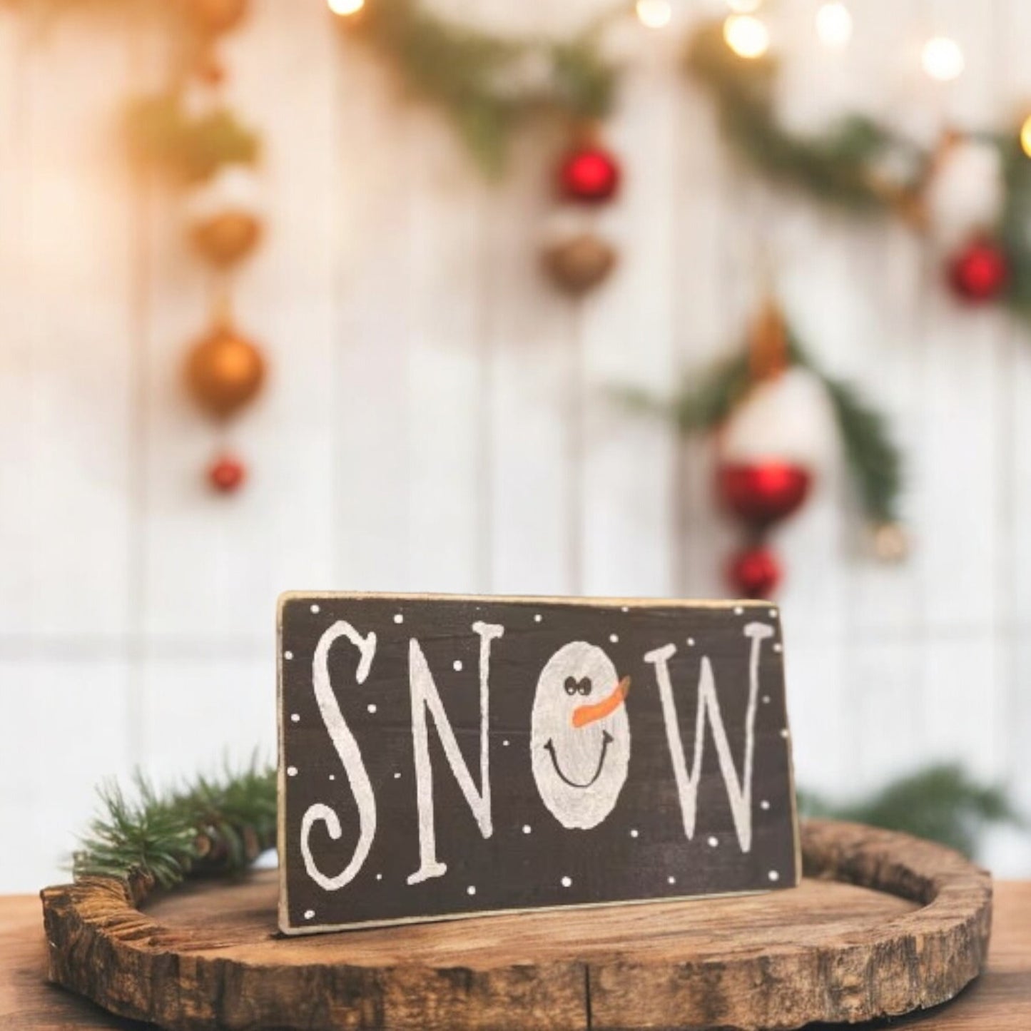 Primitive "Snow" wood block sign with a handpainted snowman as the "O" in snow, black background with white text.

