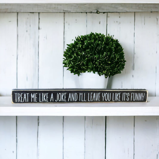 Handpainted black wood sign with white text reading 'Treat Me Like A Joke And I Will Leave You Like It's Funny,' freestanding 16-inch empowering decor for strong independent females.