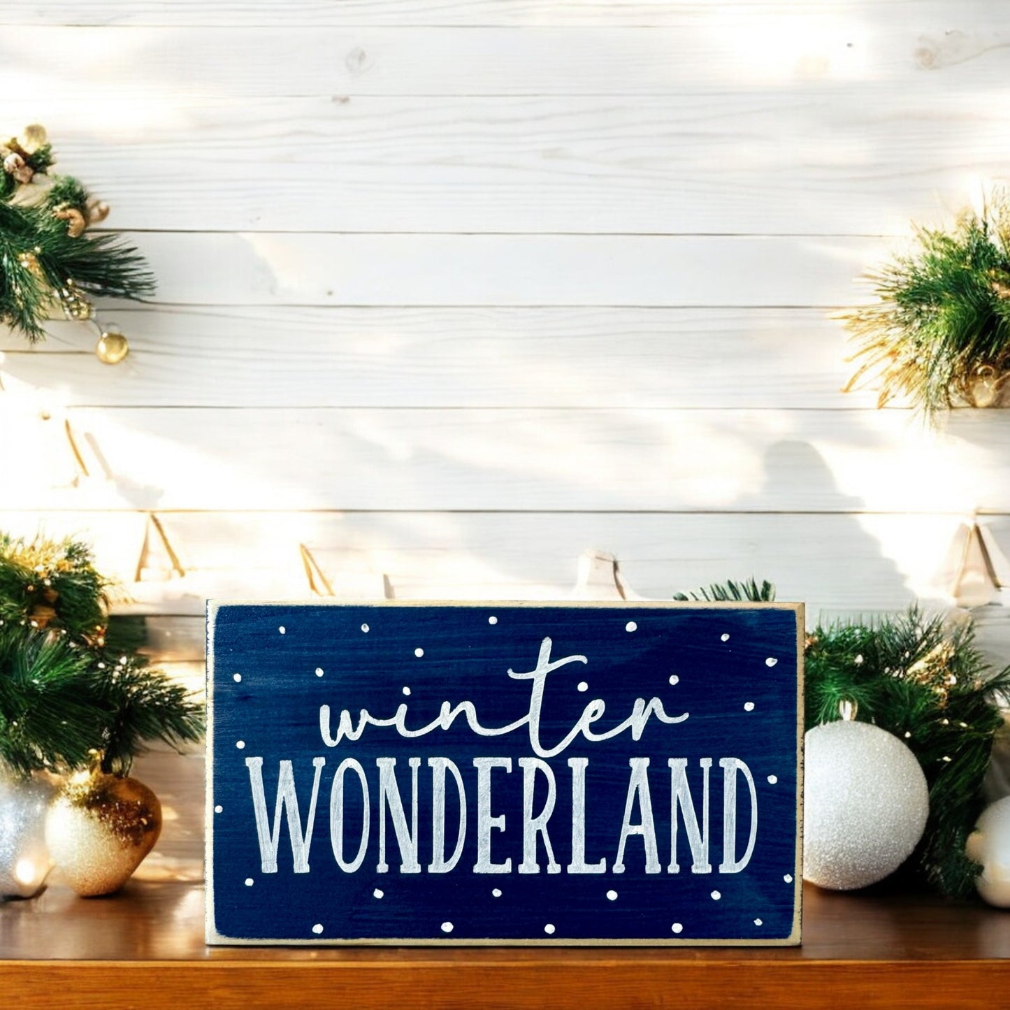 Handpainted wood block sign with “Winter Wonderland” in white text on a navy blue background, surrounded by delicate white snowflakes, ideal for winter mantel decor or home decorations.






