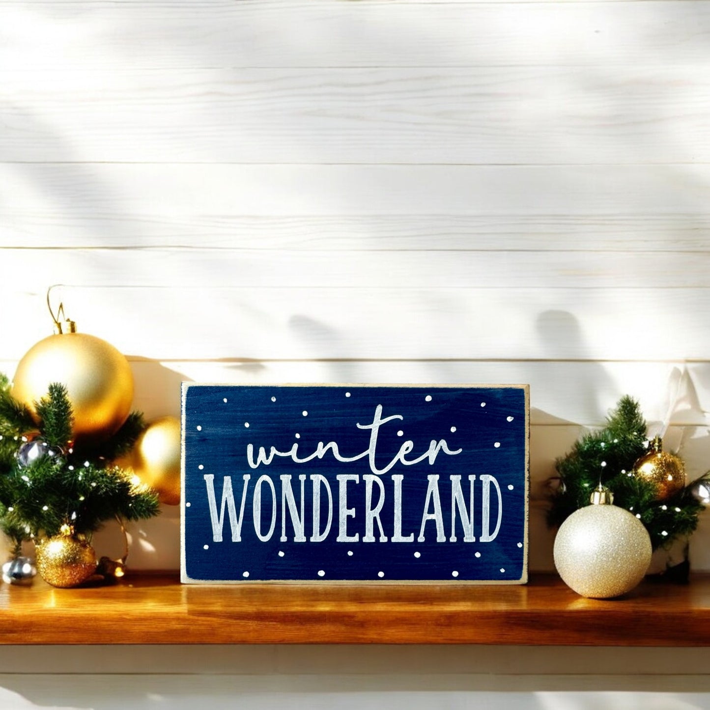 Handpainted wood block sign with “Winter Wonderland” in white text on a navy blue background, surrounded by delicate white snowflakes, ideal for winter mantel decor or home decorations.






