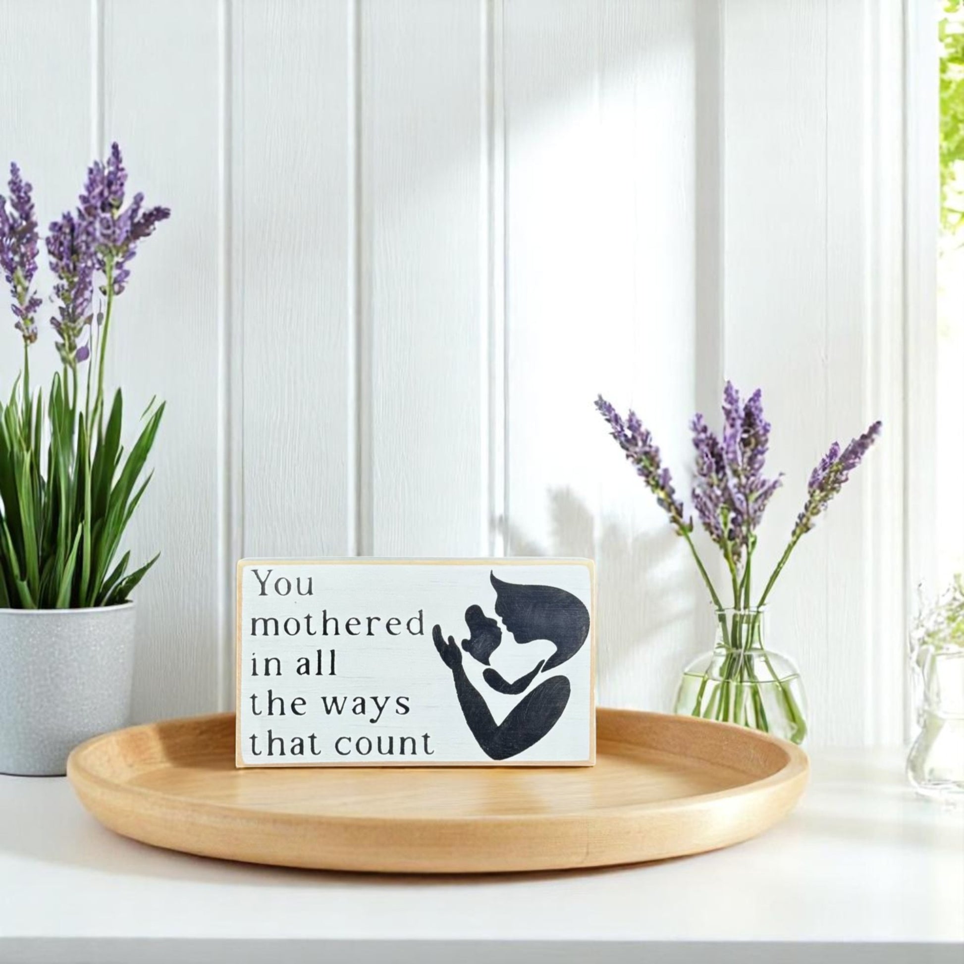 White handpainted wood block sign with black text reading, "Mom, You mothered in all the ways that count" – sentimental gift for mom.