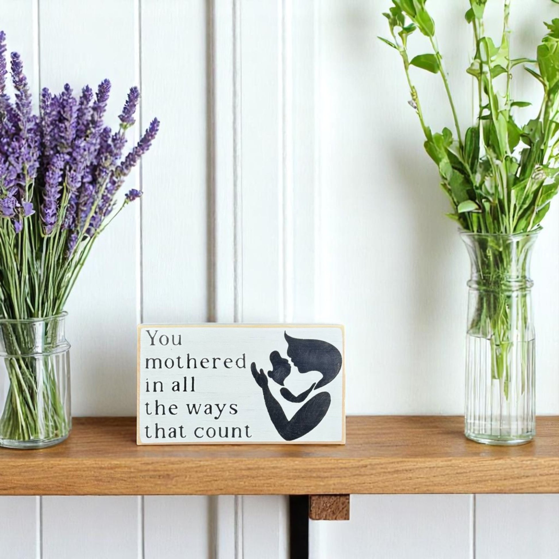 White handpainted wood block sign with black text reading, "Mom, You mothered in all the ways that count" – sentimental gift for mom.