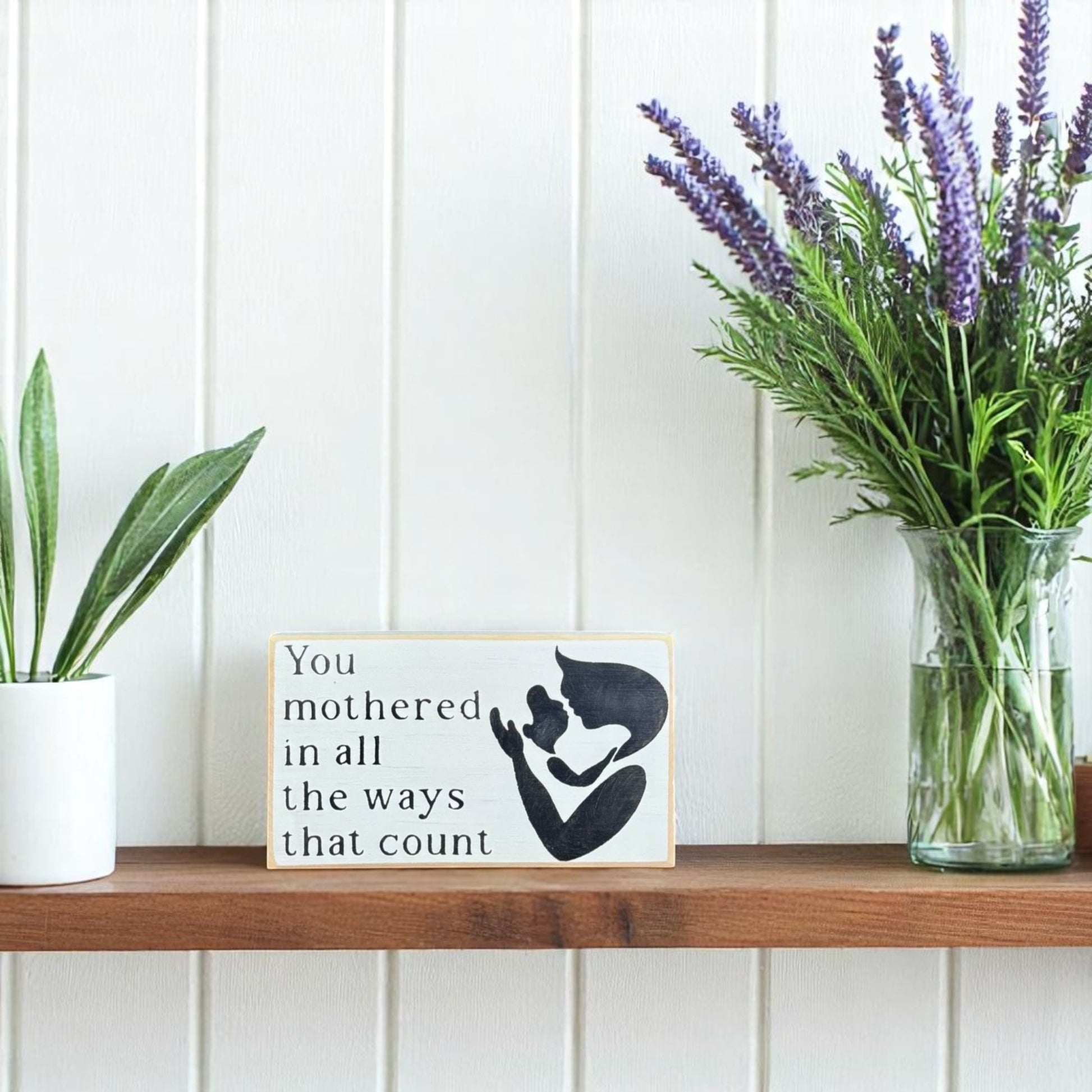 White handpainted wood block sign with black text reading, "Mom, You mothered in all the ways that count" – sentimental gift for mom.